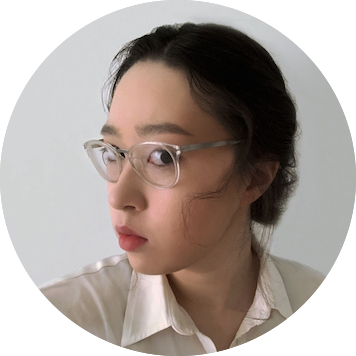 circle portrait of person with dark hair and glasses