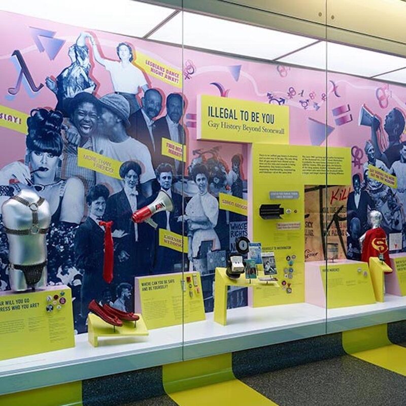 photo of a colorful display case with various artifacts and bright yellow signage